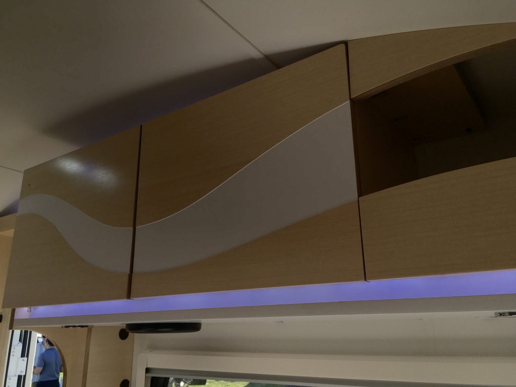 The sleek hand-crafted birch cabinetry above the kitchen area features a Wow! factor, this curved design.